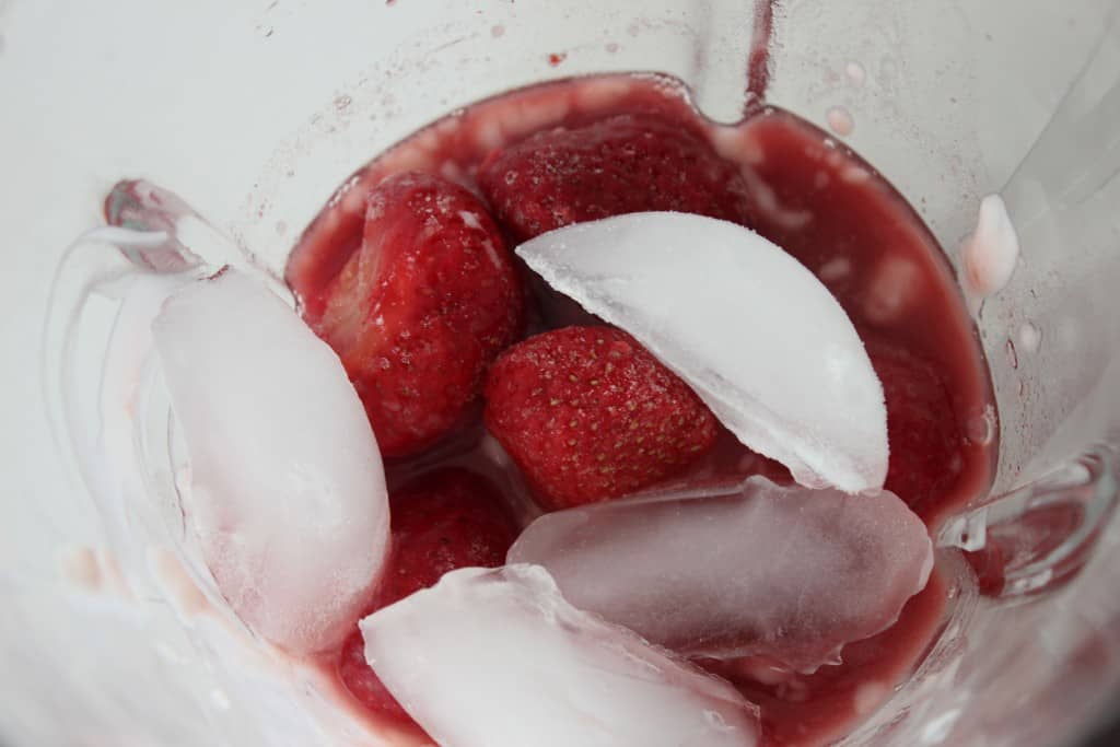 Pomegranate Strawberry Smoothie with yogurt in a cup that has not been blended yet. 