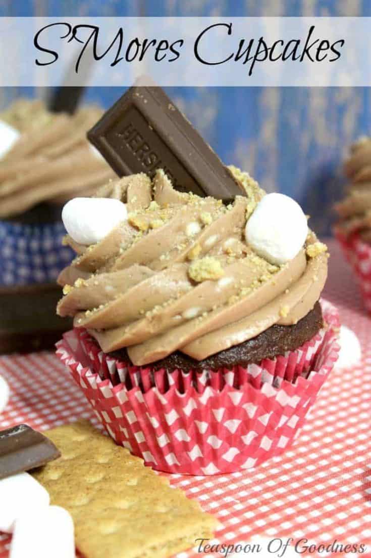 S'Mores Cupcake in a red cupcake liner with Hershey bar piece and mini marshmallows on top.