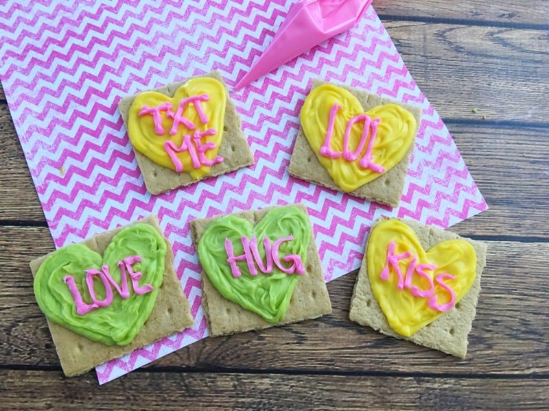 Everyone remembers the classic conversation heart candies from childhood, and now you can make this fun Valentine's Day recipe with graham crackers to resemble Conversation Hearts with your kids! - Teaspoon Of Goodness