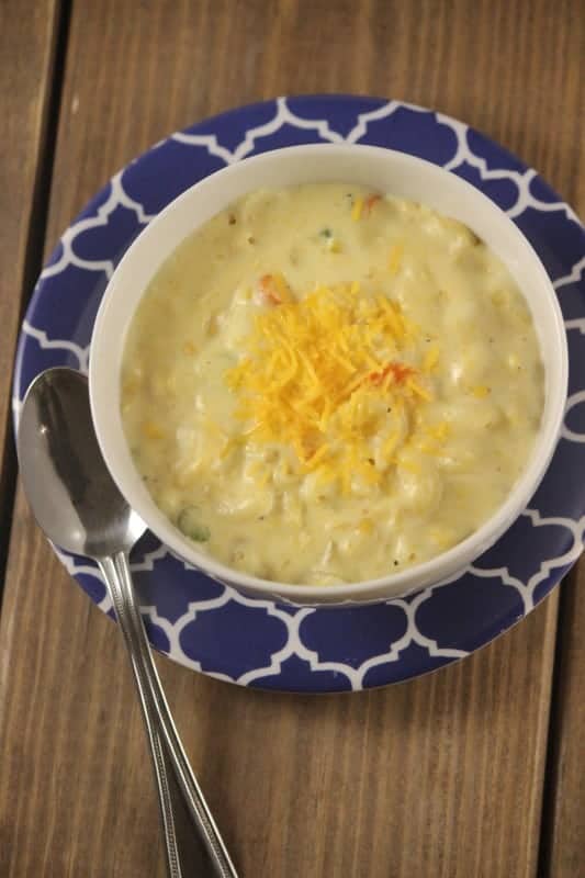 Macaroni And Cheese Soup in a blue bowl with silver spoon