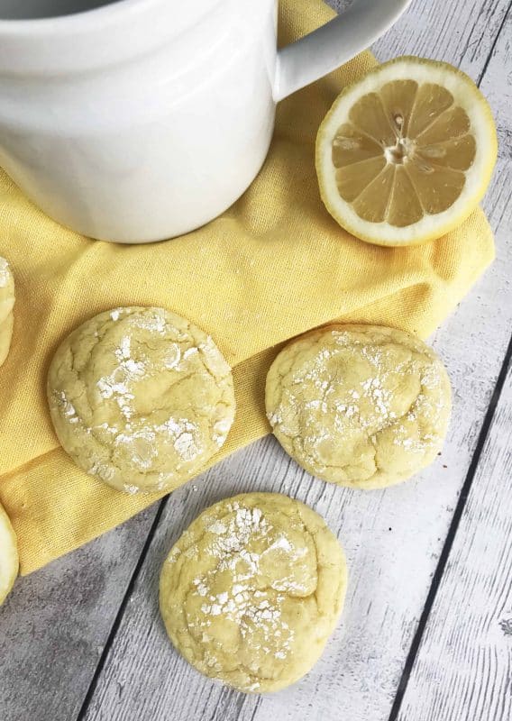 3 completed lemon cookies using a cake mix lemon cookie recipe with a lemon and sugar bowl in the background.