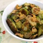 Boiled bacon and brussel sprouts in a white bowl.