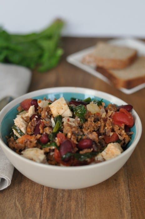 Peasant soup in a bowl with tomatoes, beef, kidney beans and spinach. 