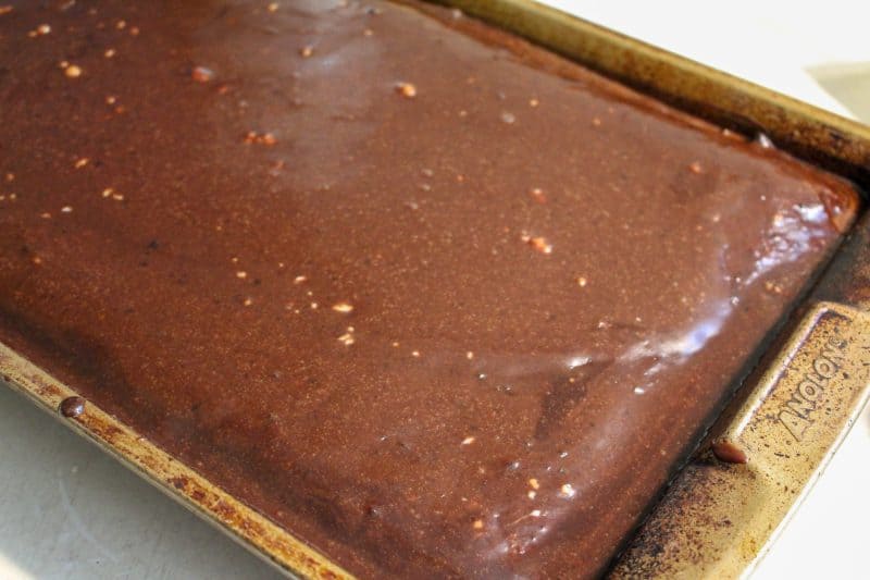 A texas sheet cake baked in a bronze baking sheet waiting to be iced. 