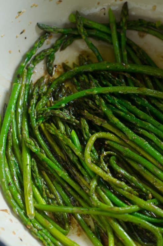 Steamed asparagus sprinkled with seas salt in a pan.